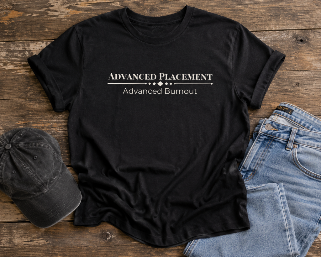 Black Advanced Placement Advanced Burnout unisex shirt displayed on a rustic wood surface with casual denim styling.