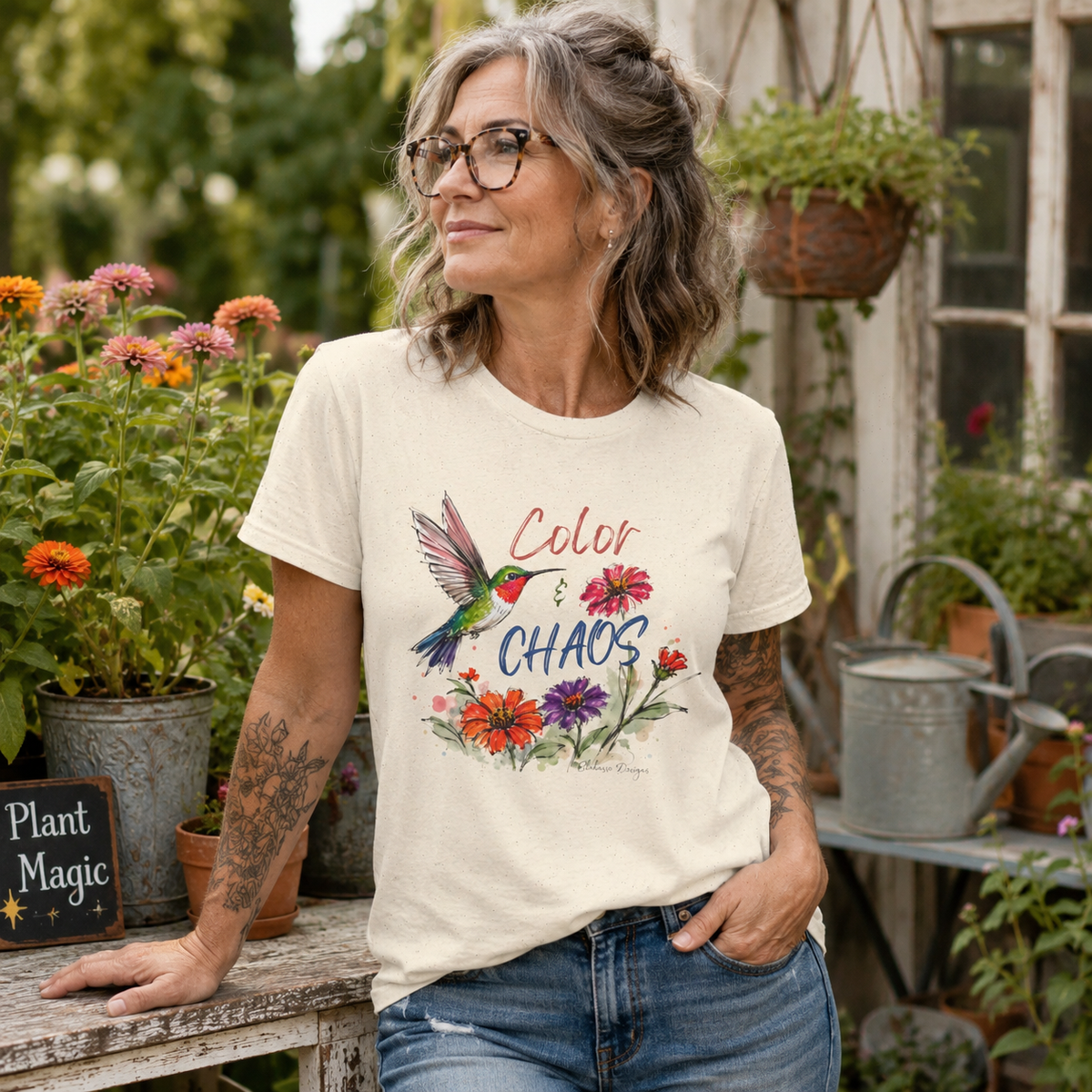 Woman wearing Color & Chaos hummingbird floral graphic tee in a garden