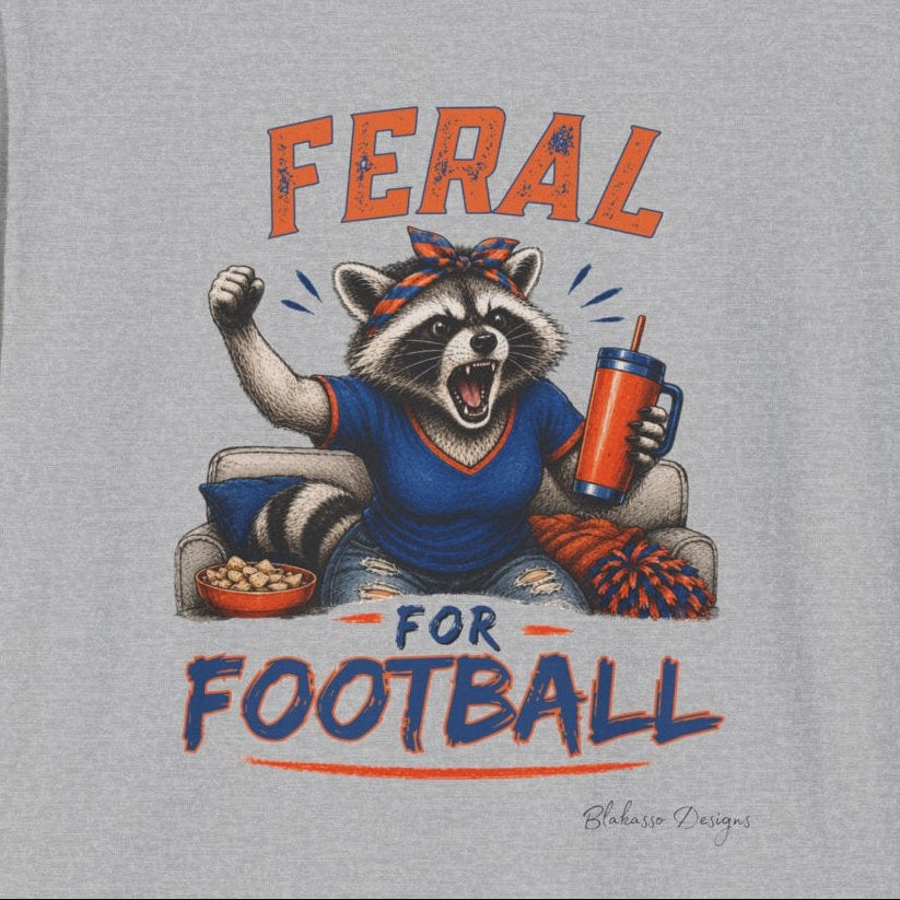 Close view of the orange and blue Feral for Football raccoon graphic printed on a gray shirt.