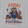 Close view of the orange and blue Feral for Football raccoon graphic printed on a gray shirt.