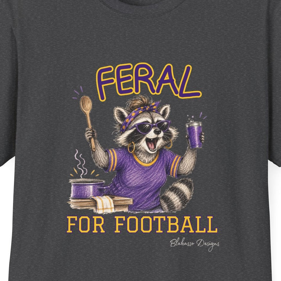 Close up of Feral for Football LSU raccoon shirt design in purple, gold, black, and graphite style on a dark heather T shirt.