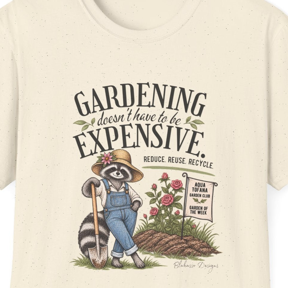 Close view of the raccoon gardener artwork, roses, garden sign, and “Gardening Doesn’t Have to Be Expensive” text on a T-shirt.