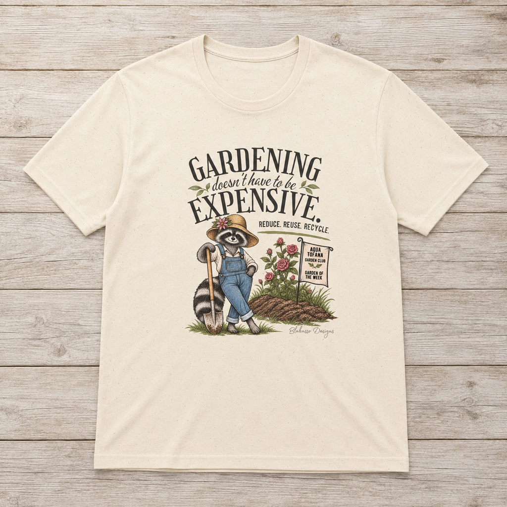Natural unisex T-shirt featuring Sammye the raccoon gardener beside roses, fresh soil, and an Aqua Tofana Garden Club sign with the text “Gardening Doesn’t Have to Be Expensive. Reduce. Reuse. Recycle.”
