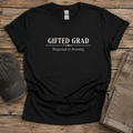 Black Gifted Grad Majored in Anxiety unisex shirt displayed on a rustic wood surface.