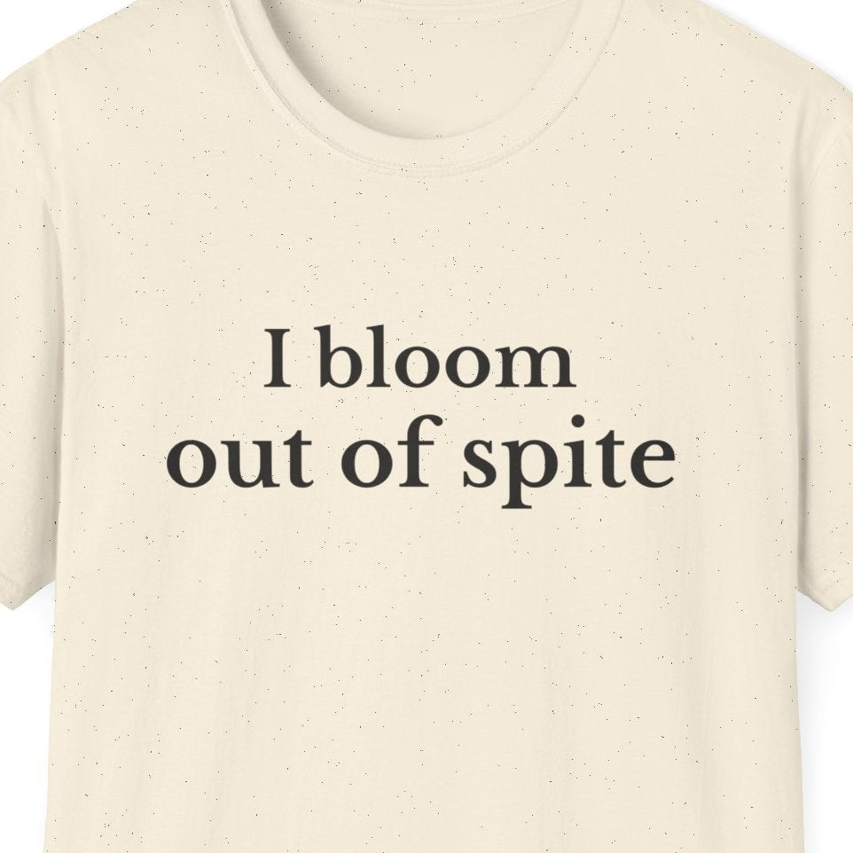 Close up of I Bloom Out of Spite minimalist serif text shirt design in Natural