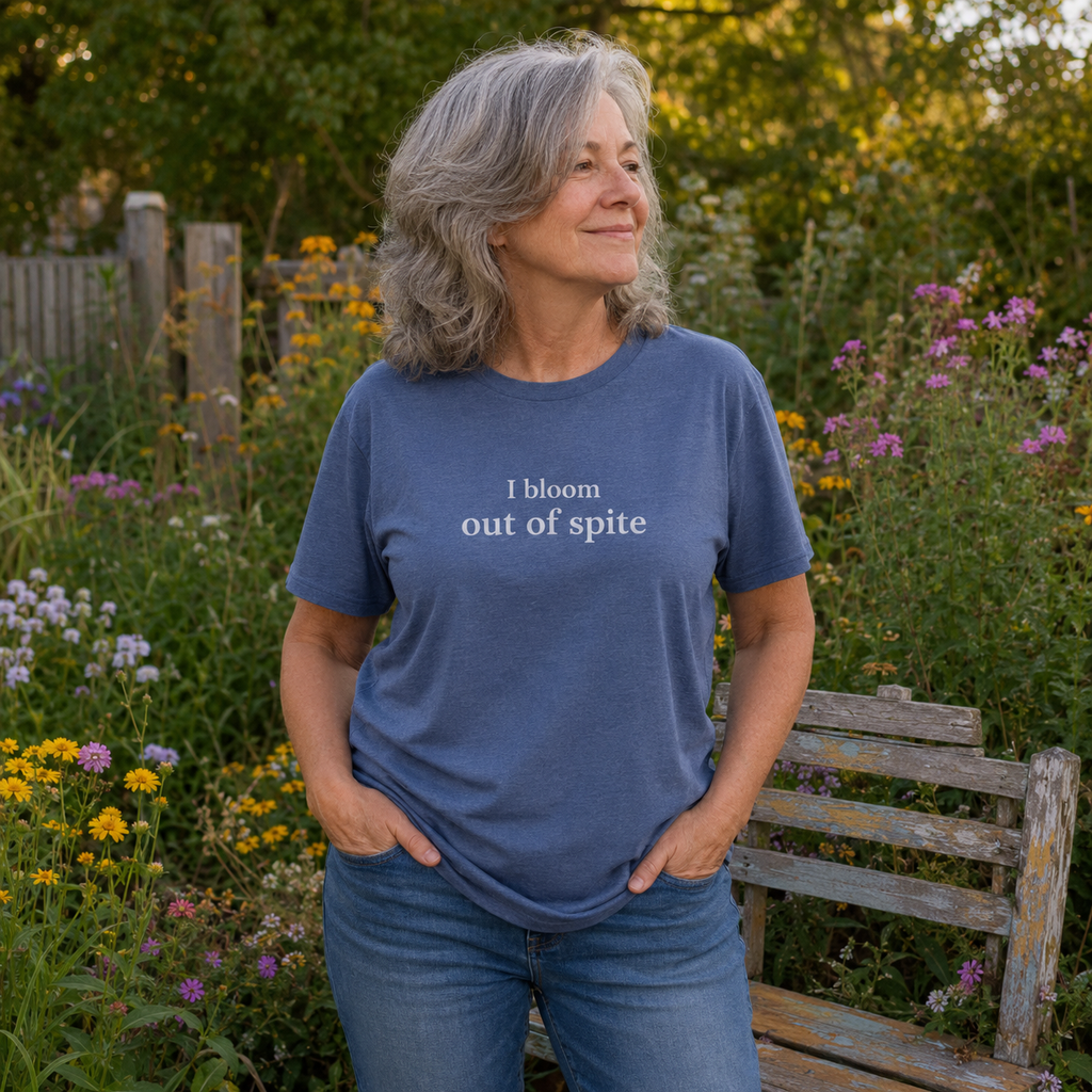 Woman wearing I Bloom Out of Spite unisex graphic tee in blue.