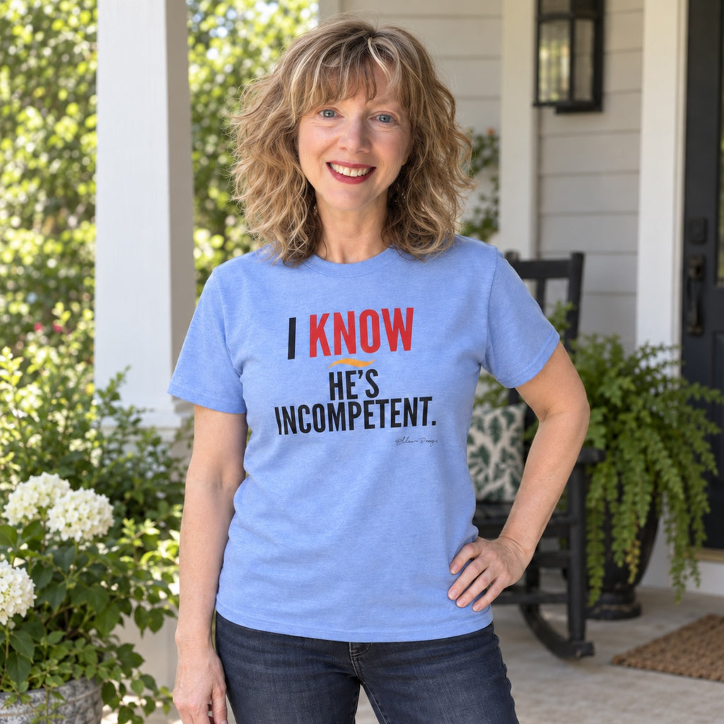 Woman wearing a Carolina Blue I Know He’s Incompetent political graphic tee on a front porch.