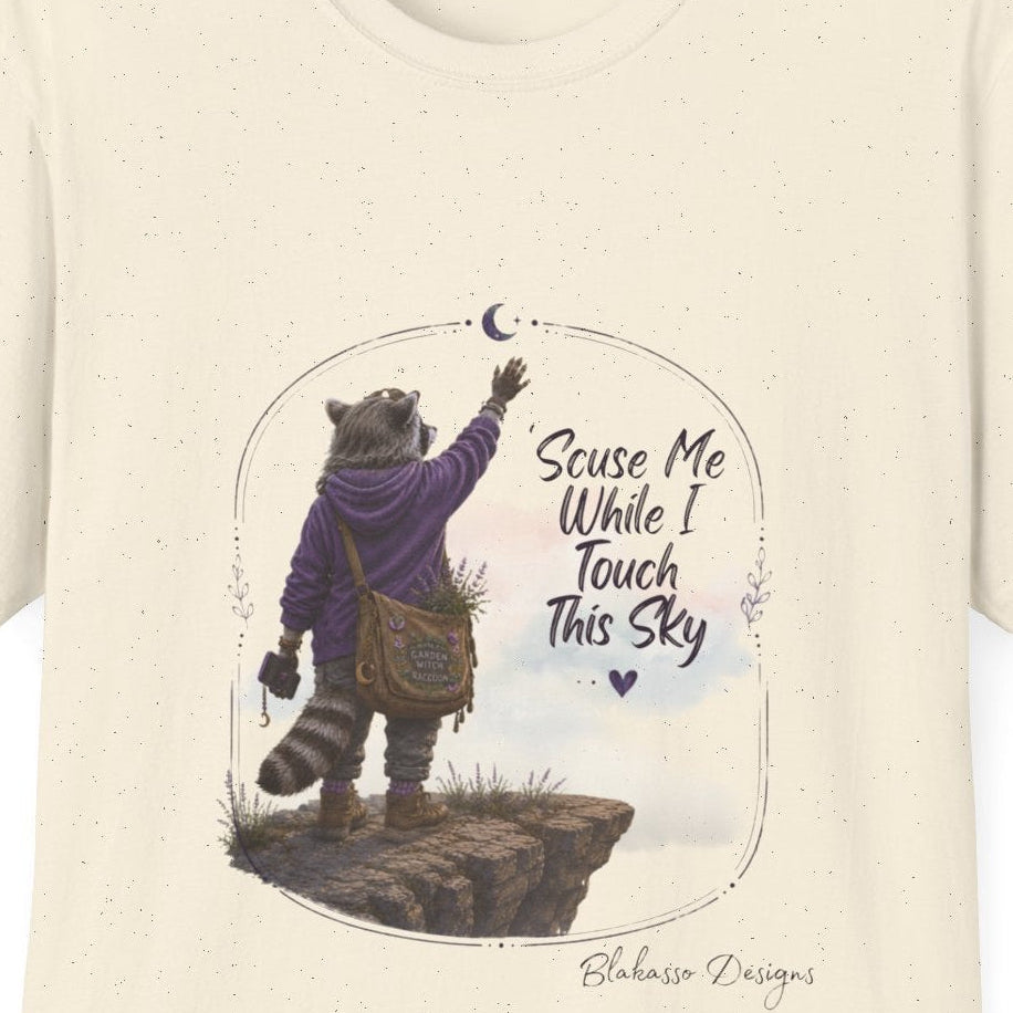 Close up of Lynette ’Scuse Me While I Touch This Sky raccoon graphic tee design in Natural
