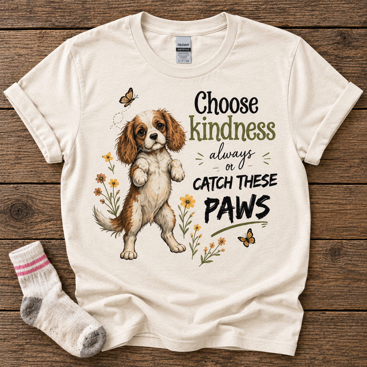 Natural T-shirt featuring the Choose Kindness Always or Catch These Paws Cavalier puppy design, styled with a stolen sock.