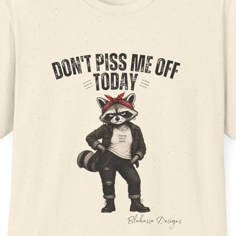 Close up of the Maddelynn raccoon design featuring the phrase "Don't Piss Me Off Today," a red bandana, boots, and an "I Bloom Out of Spite" shirt.