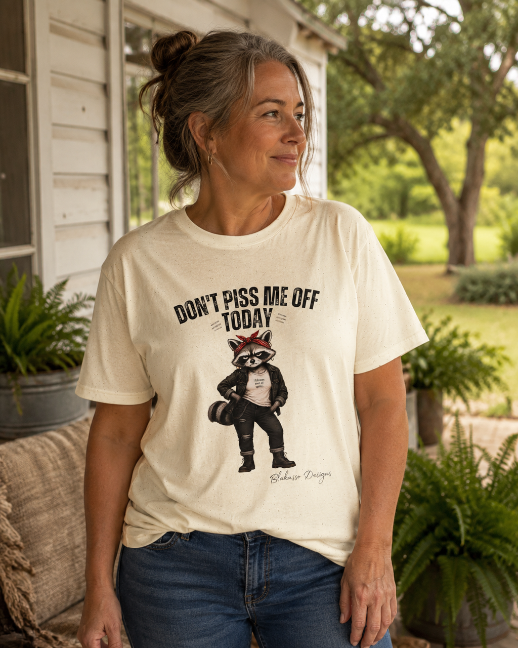 Woman wearing the "Don't Piss Me Off Today" Maddelynn raccoon graphic tee with whimsical woodland artwork and sarcastic attitude.