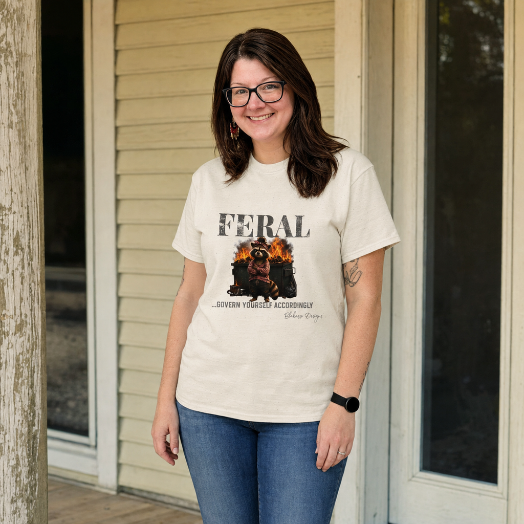 Woman wearing the “Feral...Govern Yourself Accordingly” raccoon graphic tee featuring a burning dumpster design.