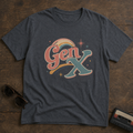 Charcoal Gen X graphic tee featuring weathered retro lettering in faded coral, teal, cream, and gold with a rainbow and starburst design.
