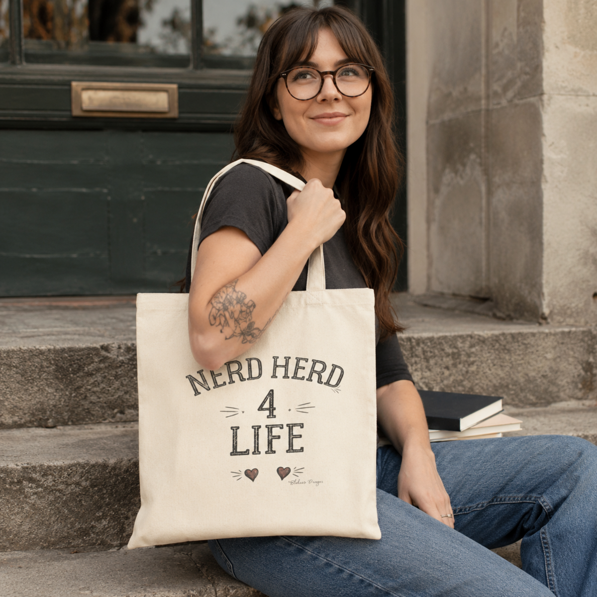 Woman carrying a Natural Nerd Herd 4 Life tote while sitting with books in a casual outdoor setting.
