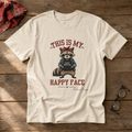 Natural unisex graphic tee featuring an unimpressed raccoon in a denim jacket and red bandana with the words “This Is My Happy Face.”